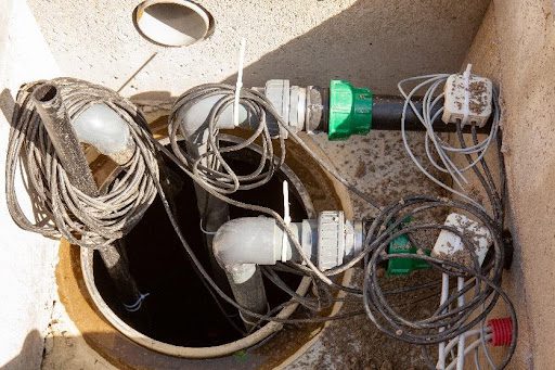 A residential backup sump pump system with wiring around it that needs to be installed by a plumber in Nixa, MO.