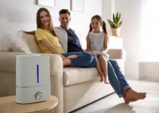 A family sits comfortably on a couch and looks at their modern air purifier in their Springfield, MO, home.